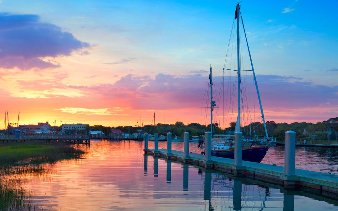 Boat in water at sunset next to dock